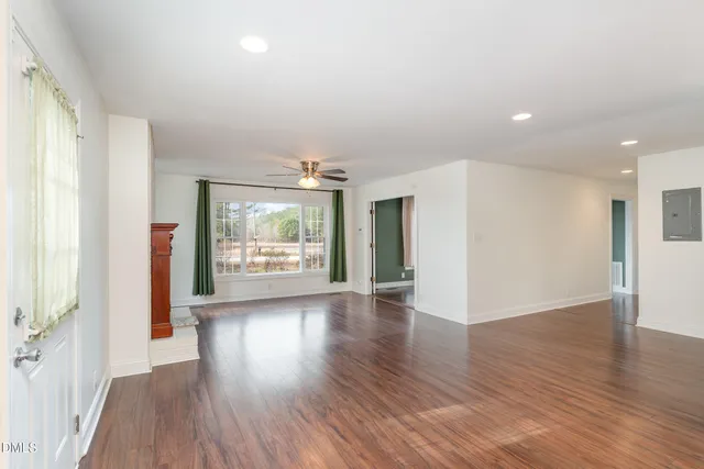 a view of room with wooden floor and windows