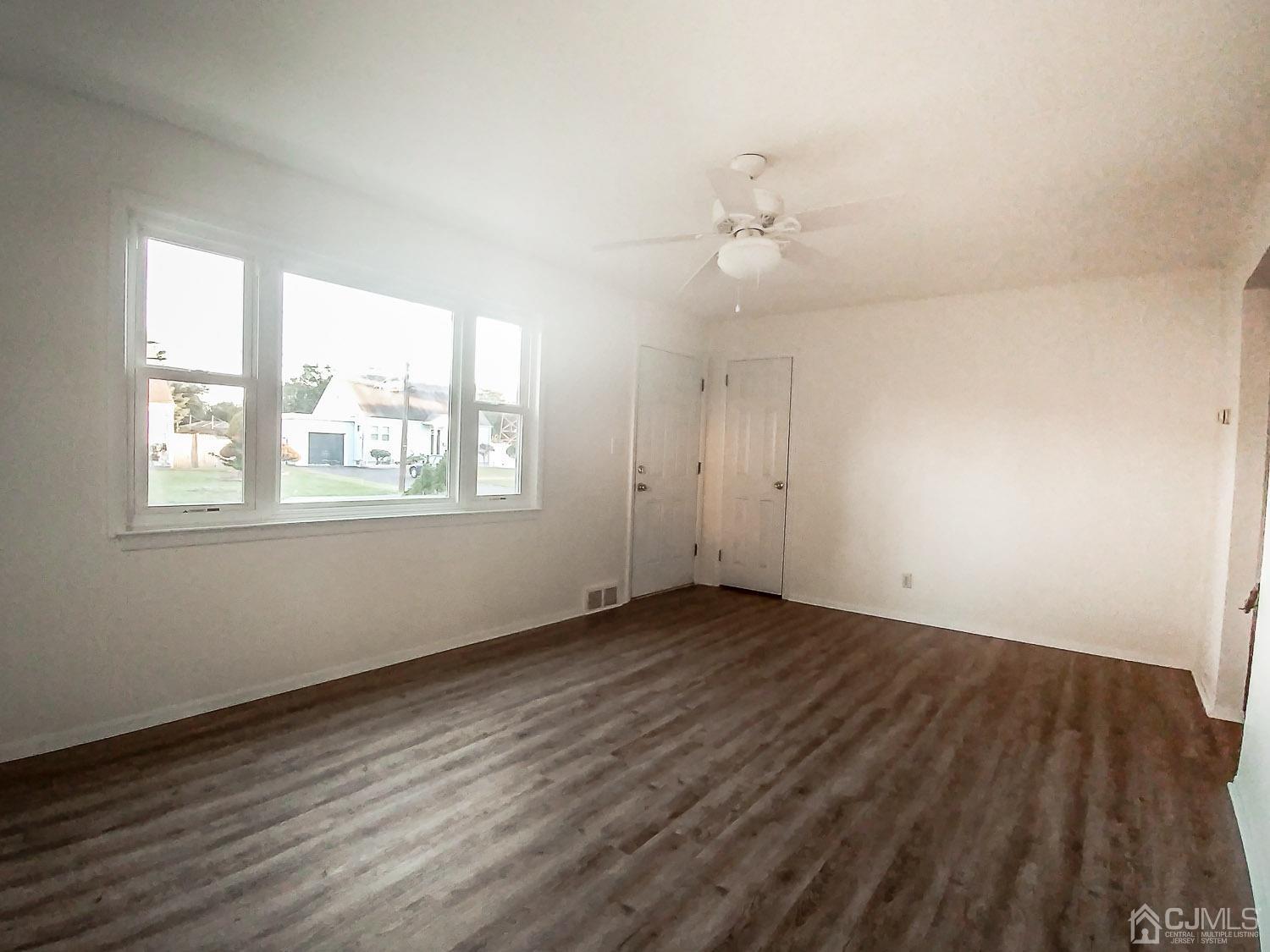 28 Longfield Road New Brunswick, NJ 08901 - Photo 3 of 14 an empty room with wooden floor and windows
