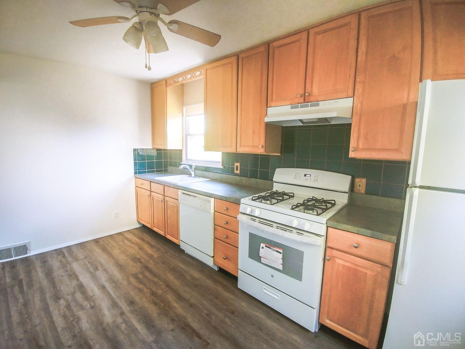 28 Longfield Road New Brunswick, NJ 08901 - Photo 6 of 14 a kitchen with a stove a sink and a microwave