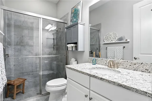 a bathroom with a granite countertop sink toilet and shower