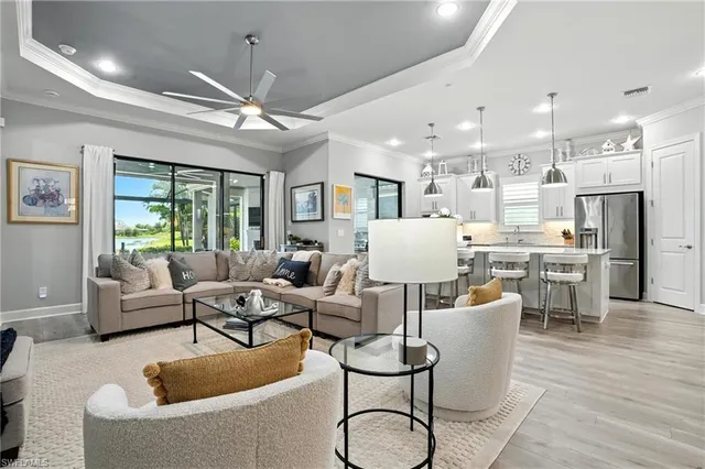 a living room with furniture kitchen view and a chandelier