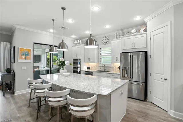 a kitchen with a refrigerator a sink and chairs