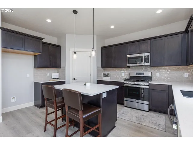 a kitchen with stainless steel appliances kitchen island granite countertop a sink counter space and cabinets