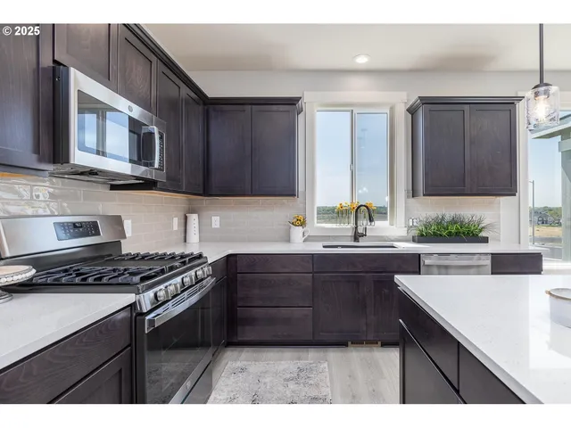 a kitchen with stainless steel appliances a sink stove and cabinets