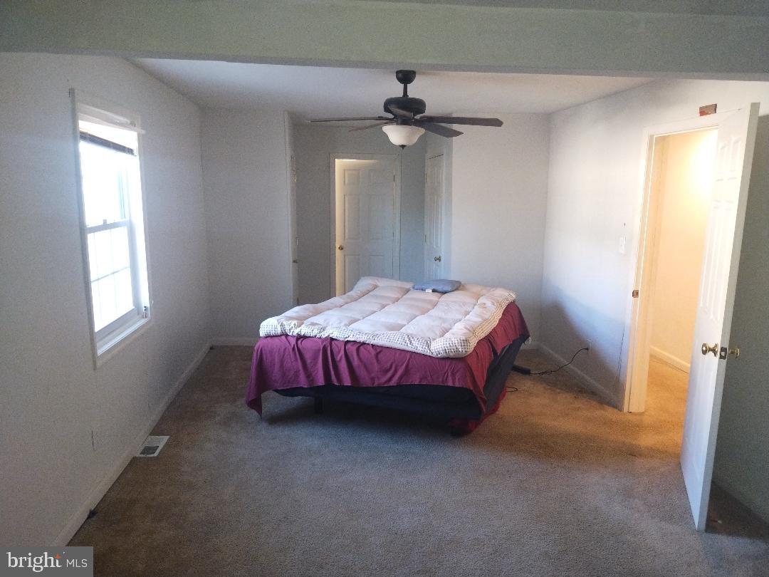 2608 Sansbury Road Upper Marlboro, MD 20774 - Photo 9 of 41 a spacious bedroom with a bed and a chandelier