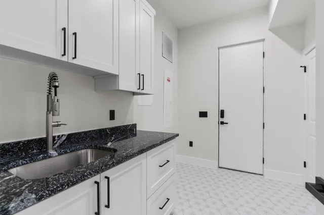 a kitchen with granite countertop white cabinets and stainless steel appliances
