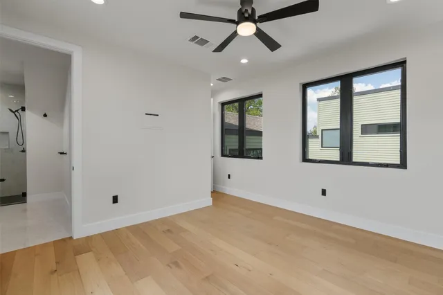 a view of an empty room with a window and a ceiling fan