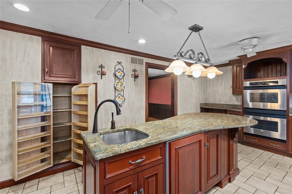 462 Adele Drive Irwin, PA 15642 - Photo 15 of 50 a kitchen with stainless steel appliances granite countertop a sink a stove and a wooden cabinets