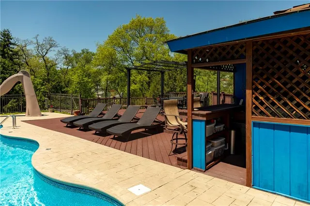 a view of a patio with table and chairs barbeque potted plants and large tree