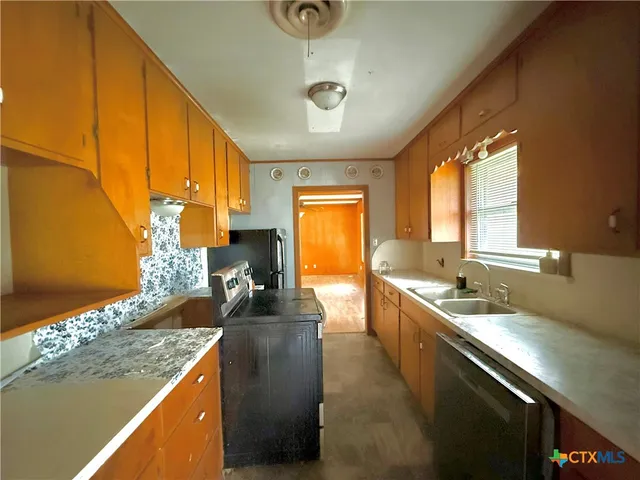 a kitchen with a sink stove and cabinets