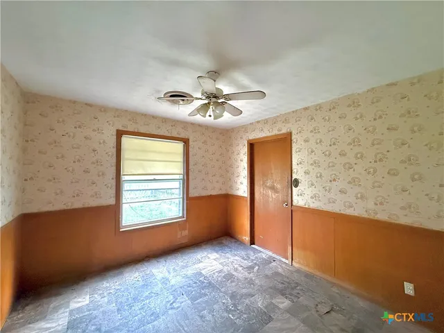 a view of a livingroom with a ceiling fan and window