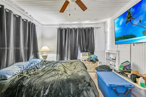 a bedroom with a bed lamp and a large window