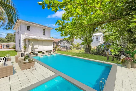 a view of a house with swimming pool and sitting area
