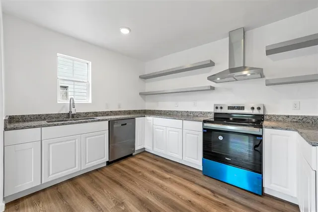 a kitchen with stainless steel appliances granite countertop a sink and stove top oven