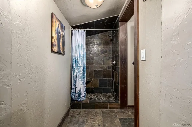 a bathroom with a glass door shower and a sink