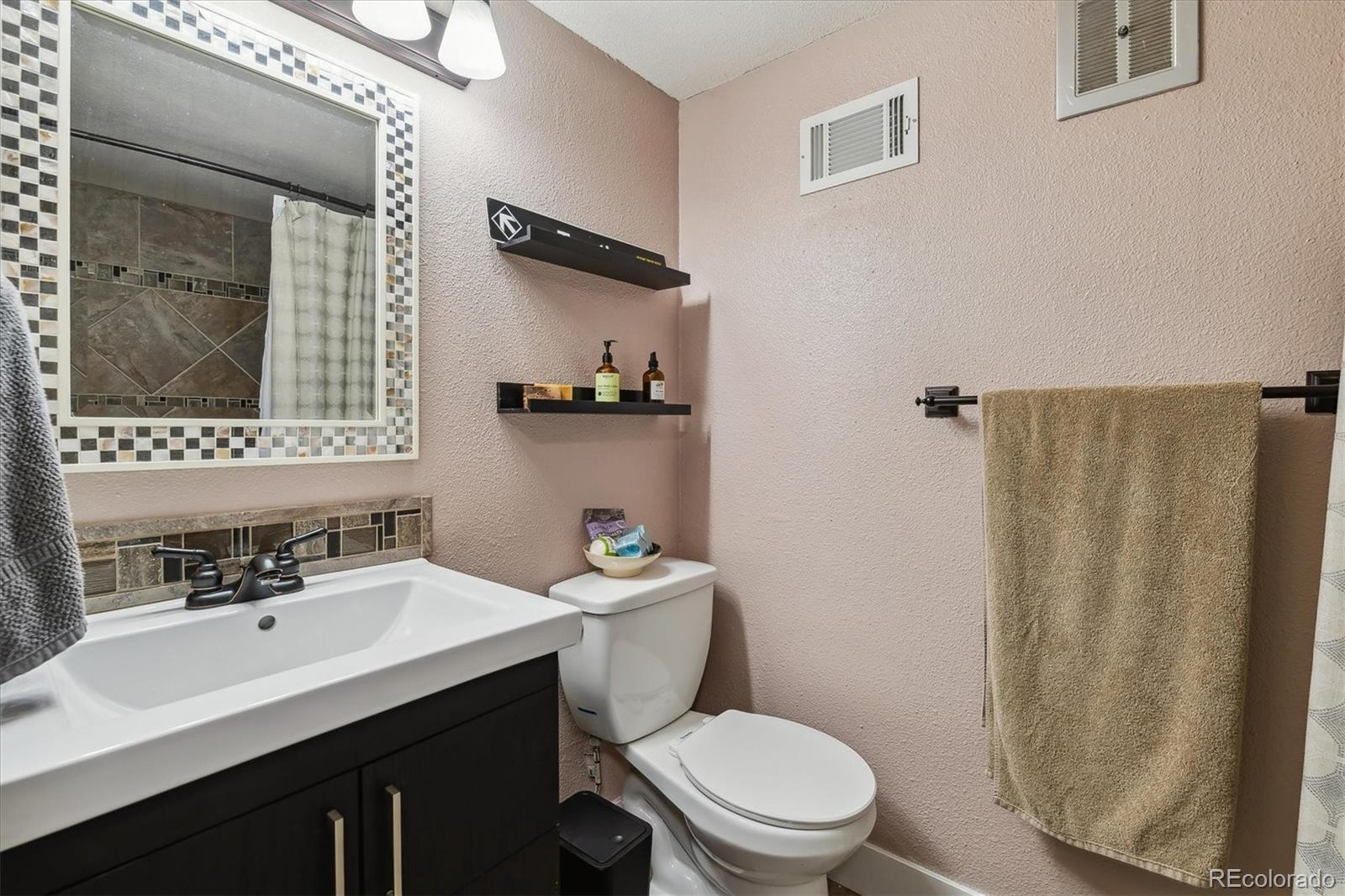 6495 East Happy Canyon Road, Unit 163 Denver, CO 80237 - Photo 13 of 27 a bathroom with a toilet a sink and mirror