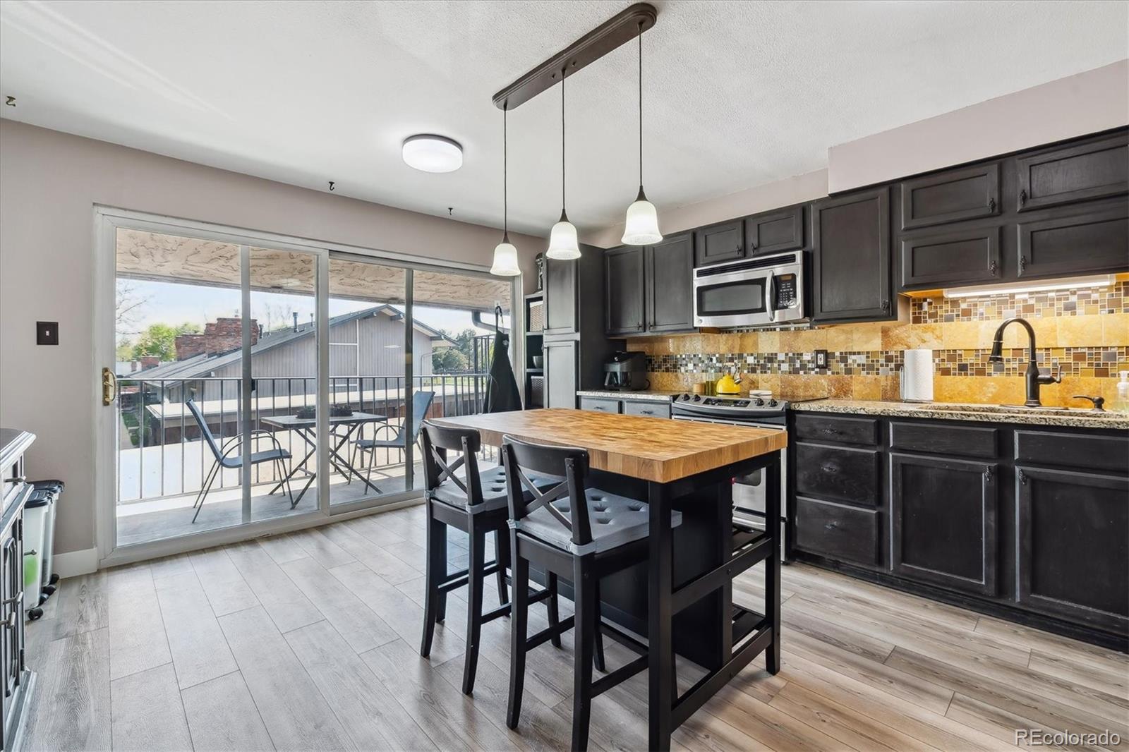 6495 East Happy Canyon Road, Unit 163 Denver, CO 80237 - Photo 2 of 27 a kitchen with granite countertop a stove a sink and a wooden cabinets