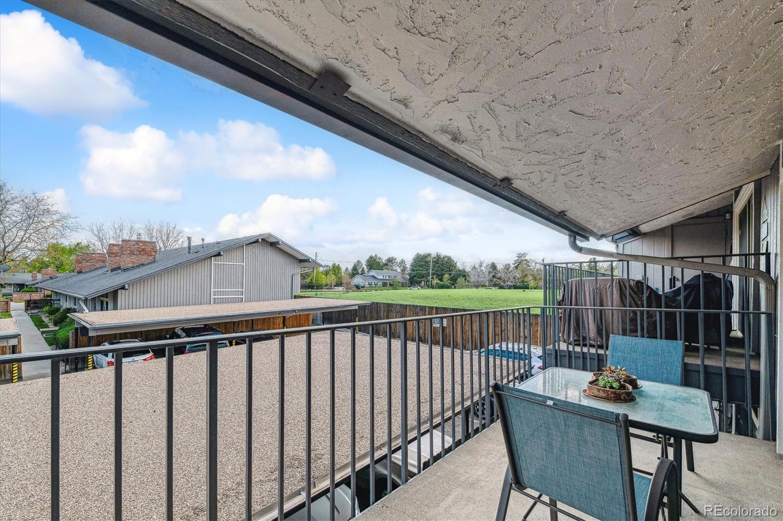 6495 East Happy Canyon Road, Unit 163 Denver, CO 80237 - Photo 21 of 27 a balcony with wooden floor outdoor seating and city view