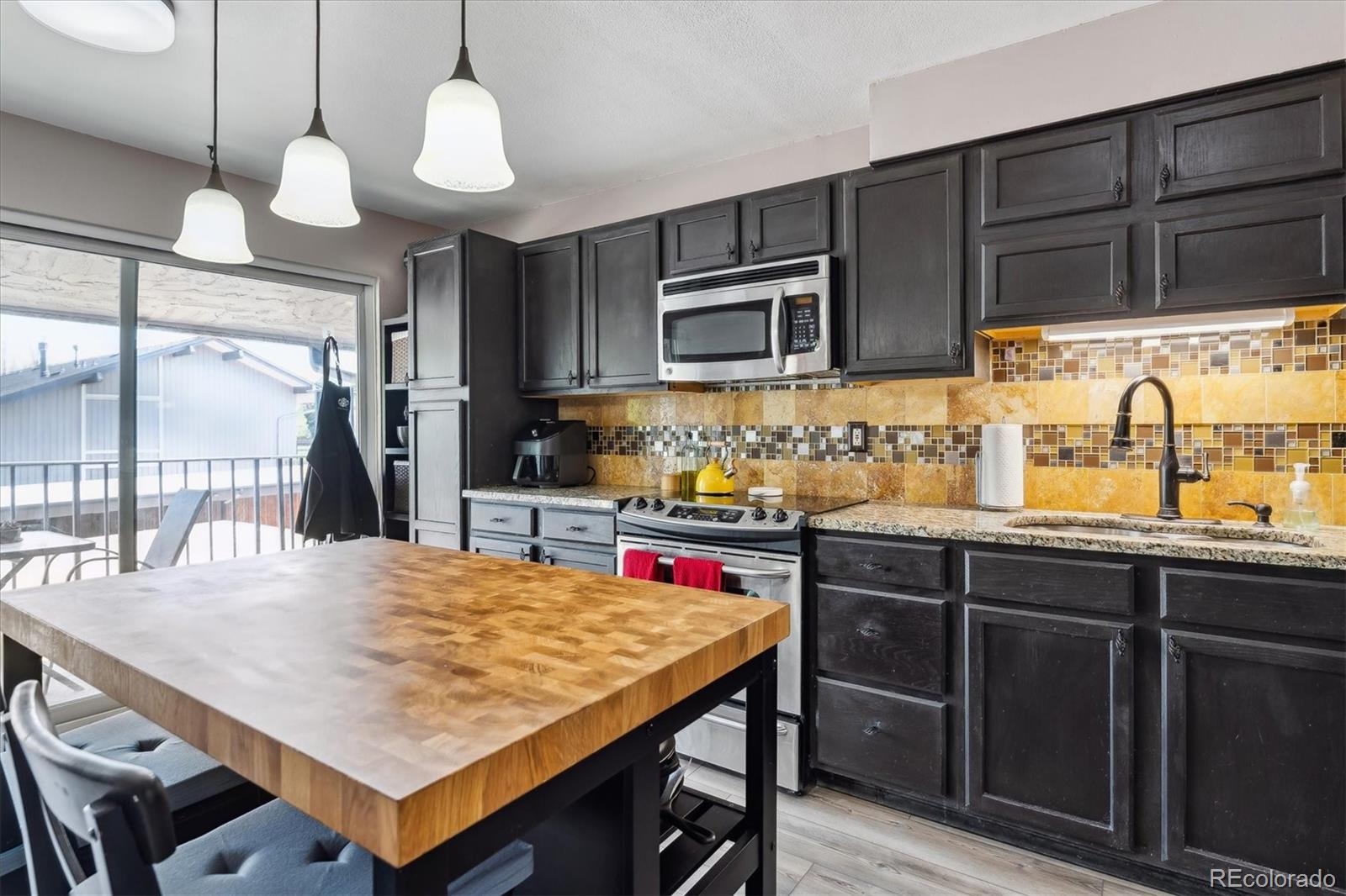 6495 East Happy Canyon Road, Unit 163 Denver, CO 80237 - Photo 5 of 27 a kitchen with stainless steel appliances granite countertop a sink a stove and a wooden cabinets