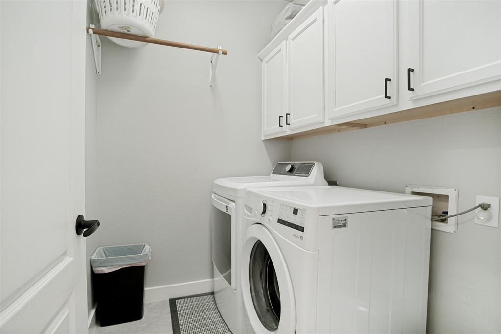 1612 Coventry Lane Allen, TX 75002 - Photo 30 of 39 Dedicated laundry area featuring white shaker-style cabinetry with matte black hardware, a light wood shelf, and light gray wall paint