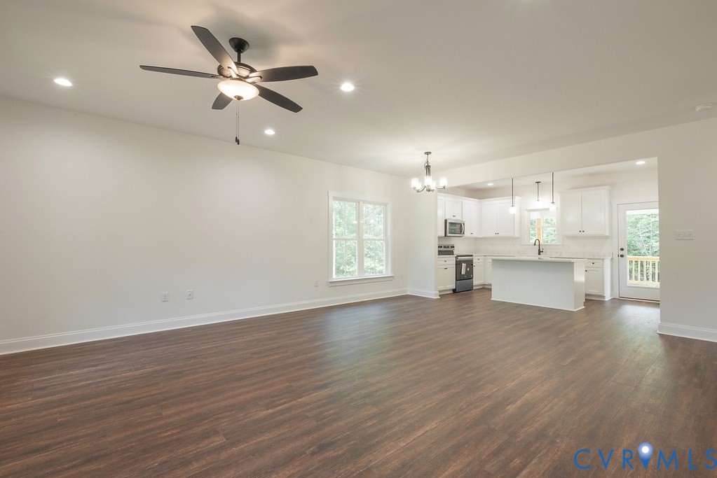 2355 Wickham Road Bumpass, VA 23024 - Photo 13 of 46 a view of an empty room with wooden floor and a kitchen