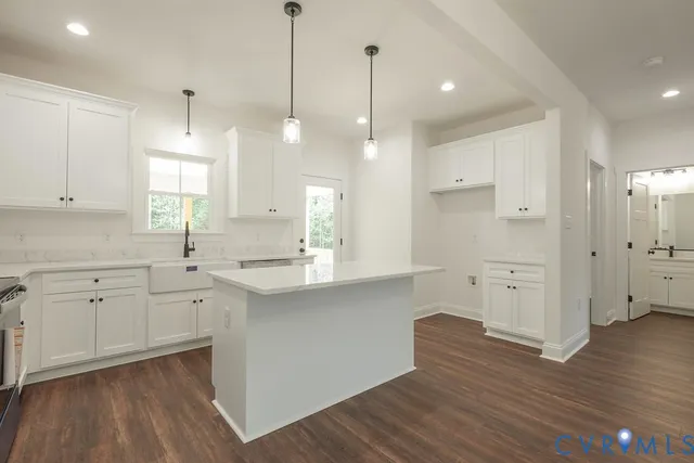 a kitchen with white cabinets and wooden floor