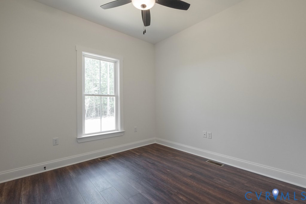 2355 Wickham Road Bumpass, VA 23024 - Photo 33 of 46 an empty room with wooden floor chandelier fan and window