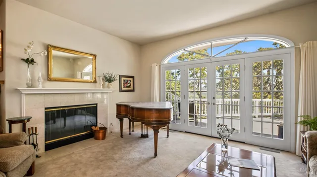 a living room with furniture a fireplace and a floor to ceiling window