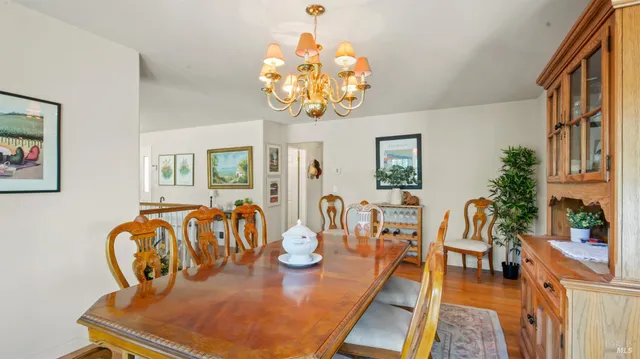 a view of a dining room with furniture a chandelier and wooden floor
