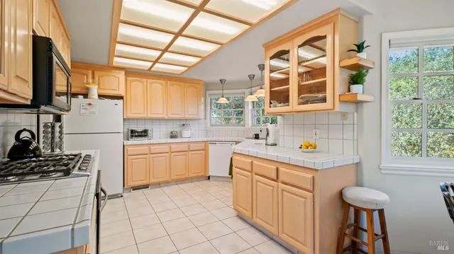 a kitchen that has a sink and chairs