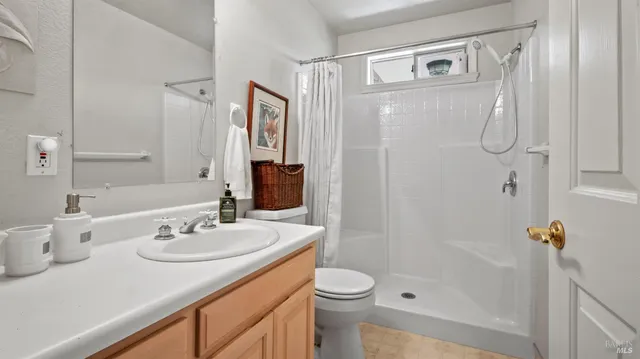 a bedroom with a bed a dresser and a large window