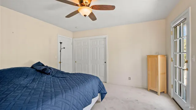 a bedroom with a large bed and a chandelier fan