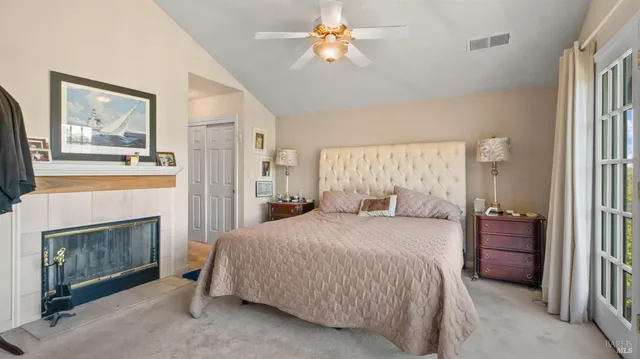a bedroom with a large bed and a flat tv screen on dresser