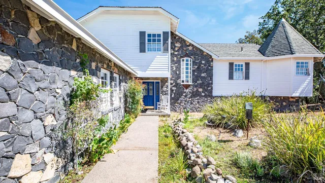 a view of a house with a yard and garden