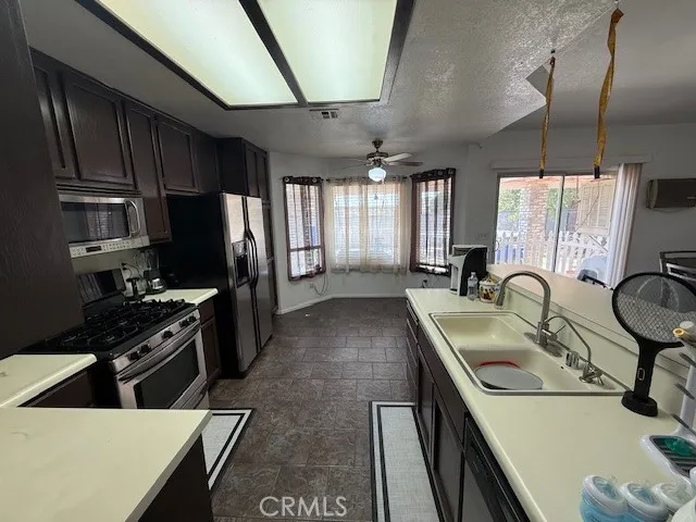 a kitchen with stainless steel appliances granite countertop a sink a stove and a refrigerator