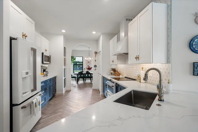 a view of a dining room and kitchen with furniture and chandelier