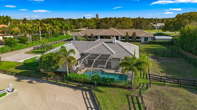an aerial view of a house with a garden and lake view