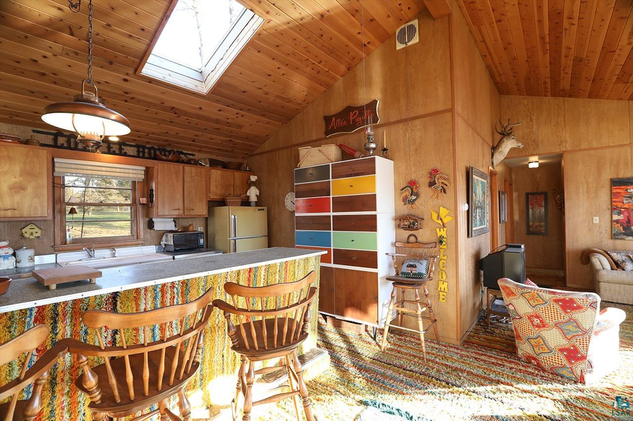 6565 White Pine Lane Gilbert, MN 55741 - Photo 7 of 25 Kitchen with freestanding refrigerator, wooden ceiling, a skylight, high vaulted ceiling, and wood walls