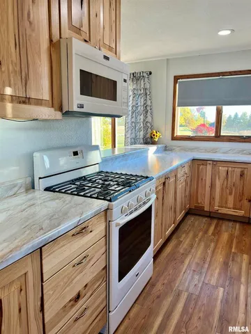 a kitchen with wooden cabinets stove and sink