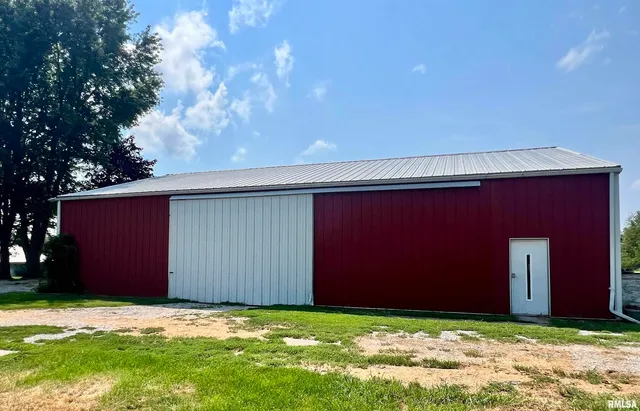an aerial view of residential house with outdoor space and trees all around