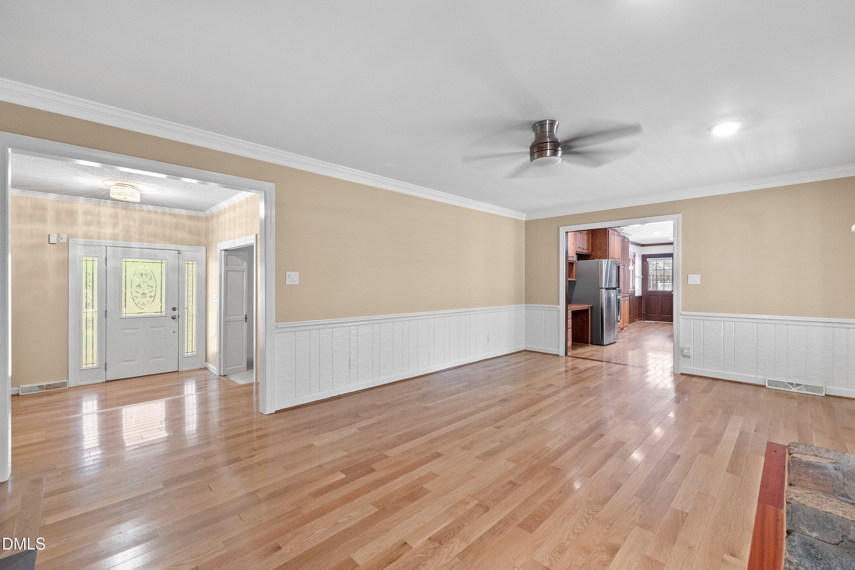 8133 Holly Forest Road Wake Forest, NC 27587 - Photo 9 of 50 a view of an empty room with wooden floor and a ceiling fan