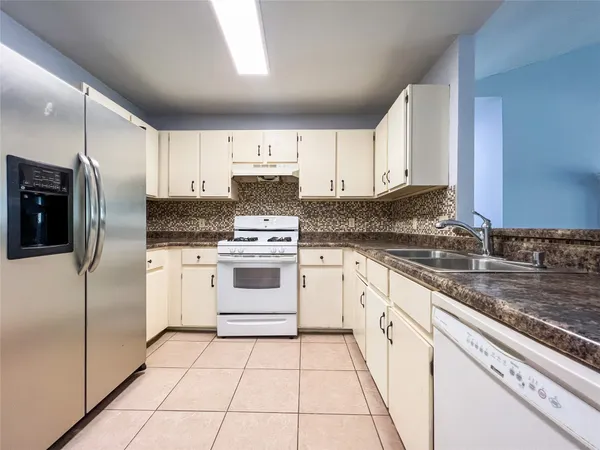 a kitchen with cabinets stainless steel appliances and a counter space