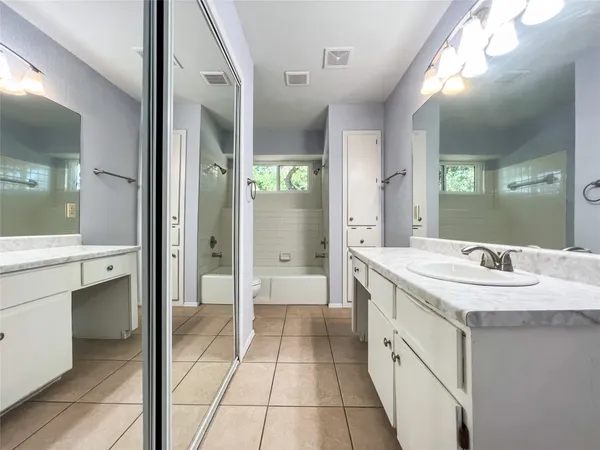 a spacious bathroom with a shower a sink and a mirror