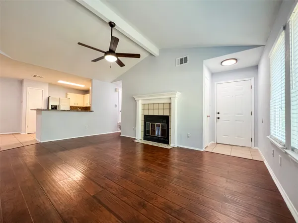wooden floor fireplace and windows in an empty room