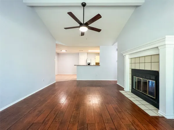 a view of empty room with wooden floor and fireplace