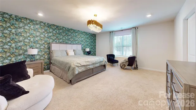 a spacious bedroom with a bed and a chandelier