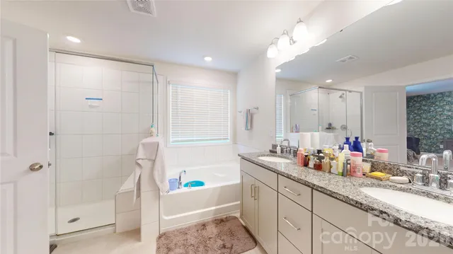 a bathroom with a double vanity sink mirror and shower