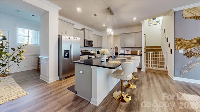 a kitchen with a sink appliances and wooden floor