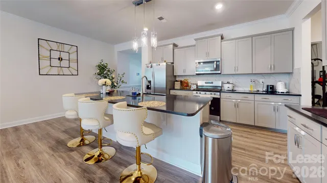 a kitchen with a dining table chairs sink and cabinets