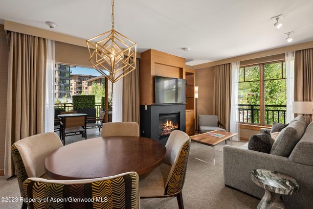 a living room with furniture a fireplace and a floor to ceiling window